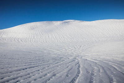 Scenic view of snowcapped mountains against clear blue sky