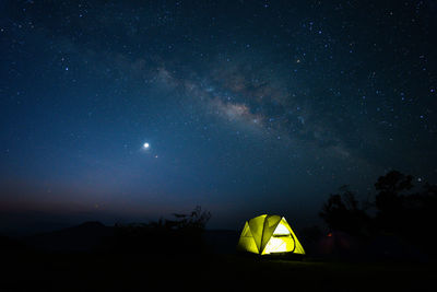 Milky way with meteor star and hiking tent in summer time