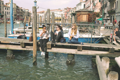 People on boat in city against sky