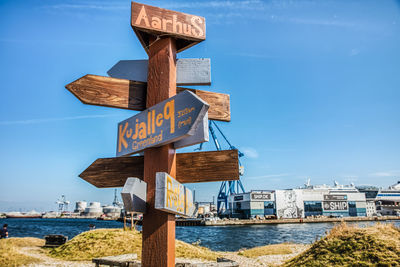 Information sign on shore against blue sky