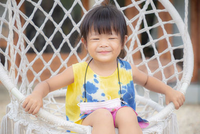 Portrait of smiling girl sitting outdoors