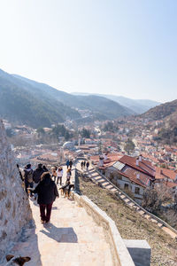 People walking on mountain against clear sky