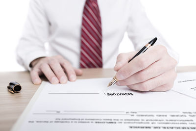 Midsection of man with umbrella on table