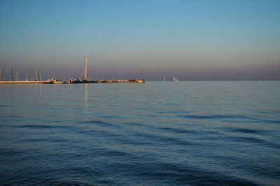 Sailboats sailing in sea against clear sky