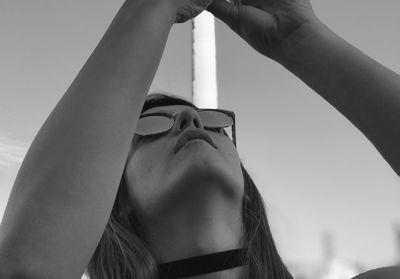 Low angle portrait of woman with arms raised