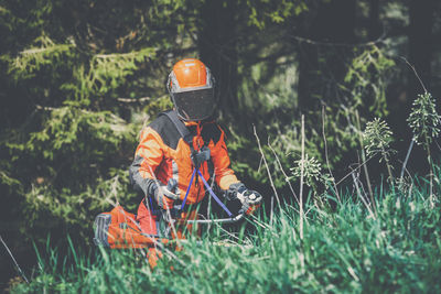 Man holding a brush cutter cut grass and brush. lumberjack at work. gardener working outdoor
