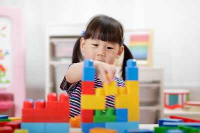 Young girl playing creative toy blocks for homeschooling