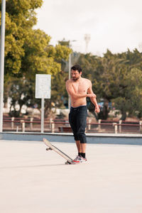 Man riding skateboard in urban street skatepark. casual guy wearing shorts and t-shirt.