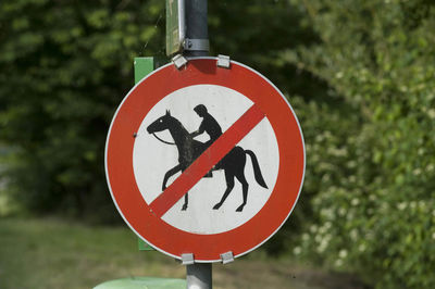 Horse riding ban road sign, red circle with pictogram of horse and rider