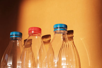 Close-up of empty glass jar on table against wall