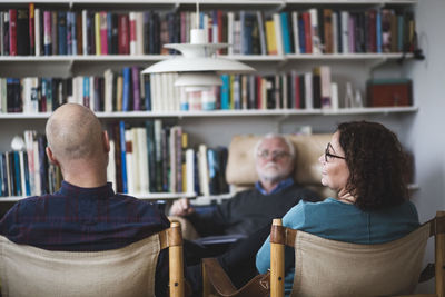 Mature couple talking while sitting with therapist at home office