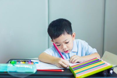 Portrait of boy with book on table