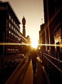 People walking on street in city at sunset