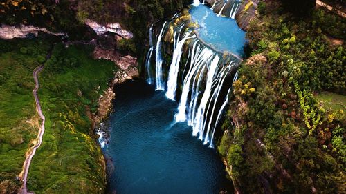 High angle view of waterfall amidst trees in forest