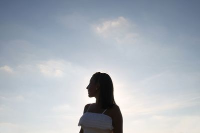 Woman looking away against sky