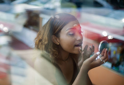 Portrait of young woman using mobile phone outdoors