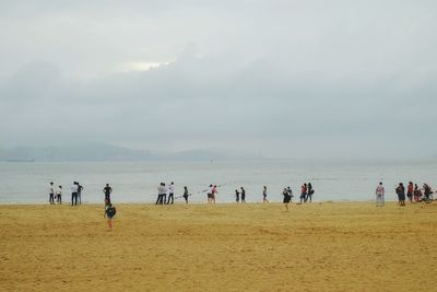 People at beach against sky