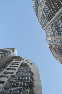 Low angle view of modern buildings against clear blue sky