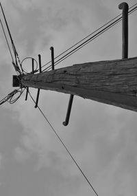 Low angle view of cables on wooden pole against sky