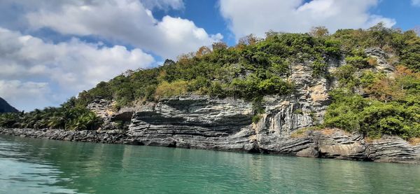 Panoramic view of rock formation amidst trees against sky