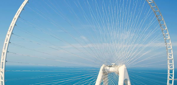 Low angle view of ferris wheel against blue sky