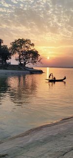 Silhouette boat in sea against sky during sunset