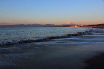 Scenic view of sea against clear sky during sunset