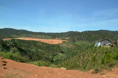 Scenic view of trees and houses against sky