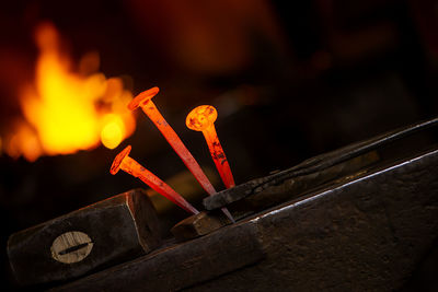 Close-up hot metal nail on an anvil in blacksmith's workshop