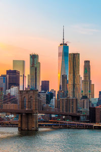 Modern buildings in city against sky during sunset