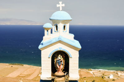 Close-up of virgin mary statue at shrine against horizon