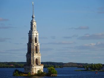 Tower of building by sea against sky
