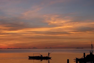 Silhouette sailboats in sea against sky during sunset