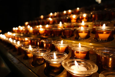 Close-up of lit tea light candles in temple