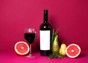 Close-up of wine bottles against red background