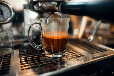 Close-up of coffee pouring in glass