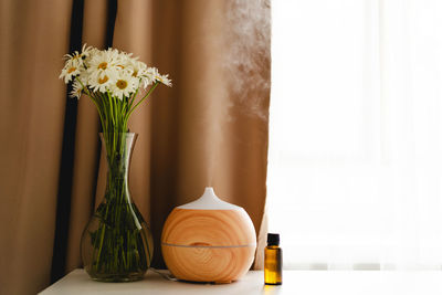 Aromatherapy concept. aroma oil diffuser on the table against the window.