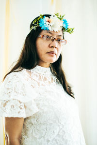 Portrait of woman standing by flower head