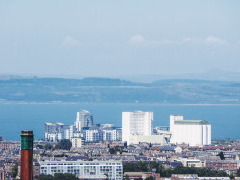 High angle view of buildings by sea against sky