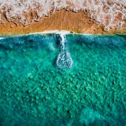 Aerial view of blue sea with splashing waves