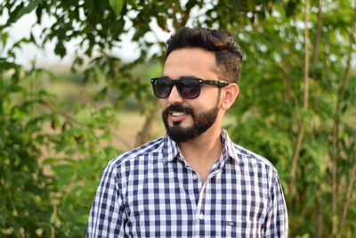 Portrait of young man wearing sunglasses standing outdoors