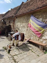 Man sitting with harmonium and notes outdoors