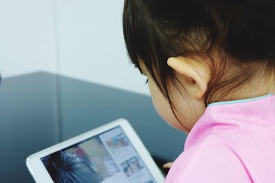 Close-up of girl using digital tablet at home