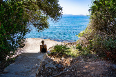 Rear view of woman looking at sea against sky