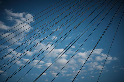 Low angle view of power lines against sky