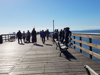 People on beach against clear sky