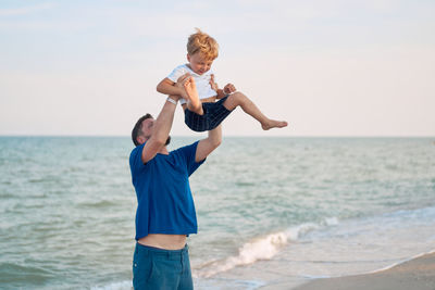 Full length of boy on beach against sky