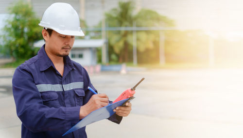 Engineer with walkie-talkie working at construction site 