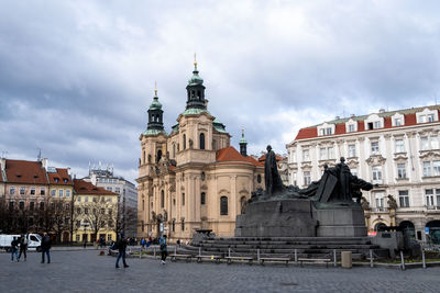 Buildings in city against cloudy sky