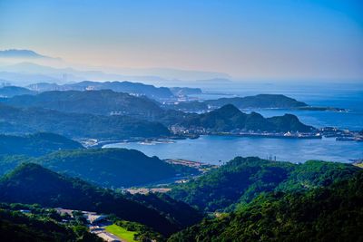 High angle view of sea and mountains against sky